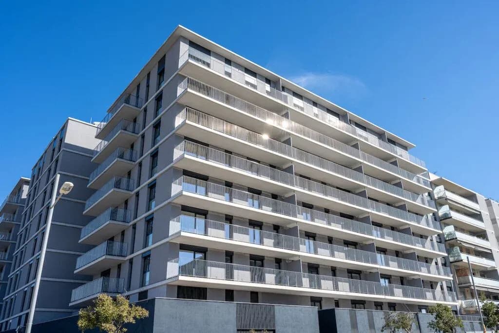 Multi-storey apartment building with rows of balconies.