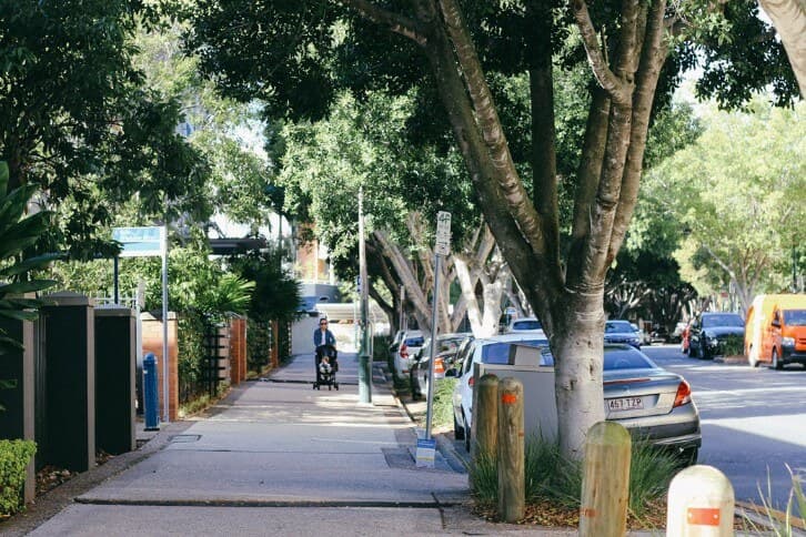 A leafy inner-Brisbane street with homes and apartments
